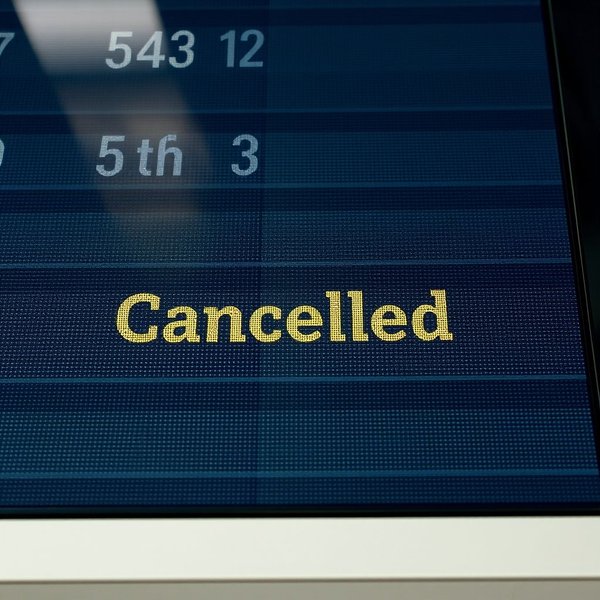 Sebuah papan keberangkatan bandara yang menunjukkan a flight cancellation.