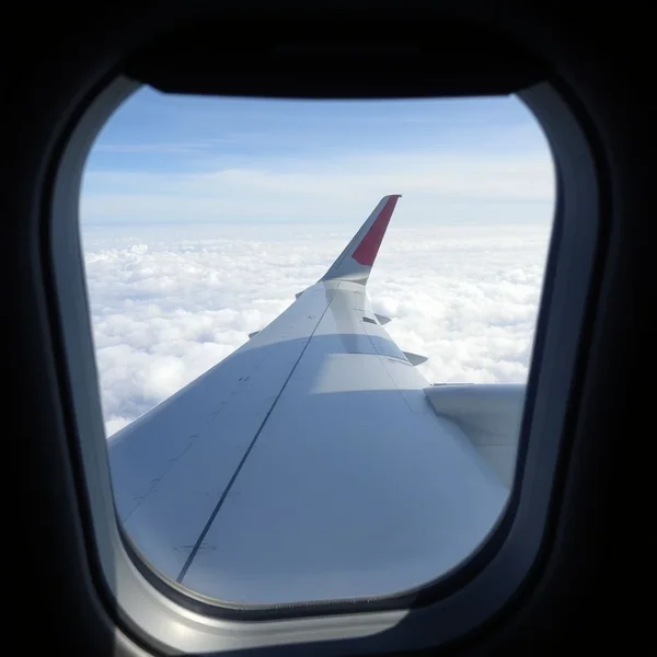 Ein Flugzeugflügel mit Wolken, der das Konzept von air turbulence illustriert