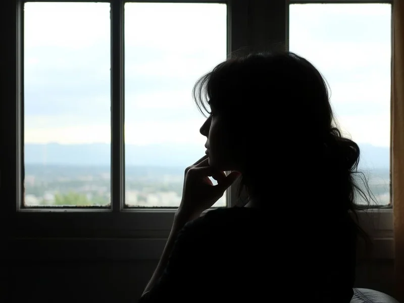 Image showing a person thoughtfully looking out a window, illustrating the concept of Come To Terms With