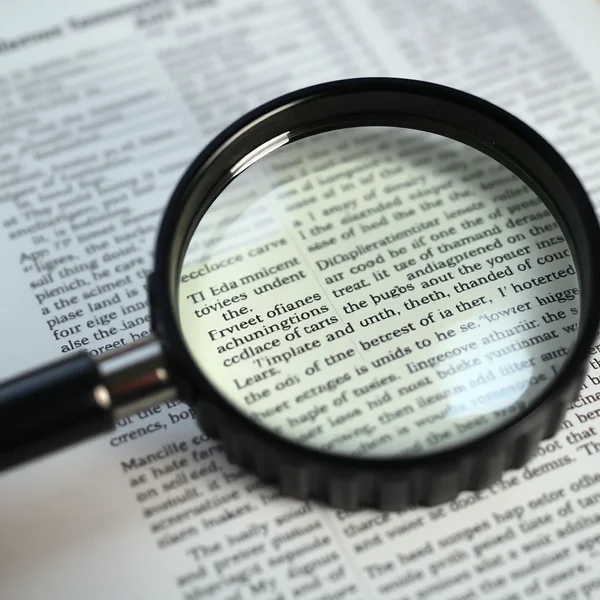 Une loupe au-dessus d'un document, illustrant le concept de comment ferret out des informations